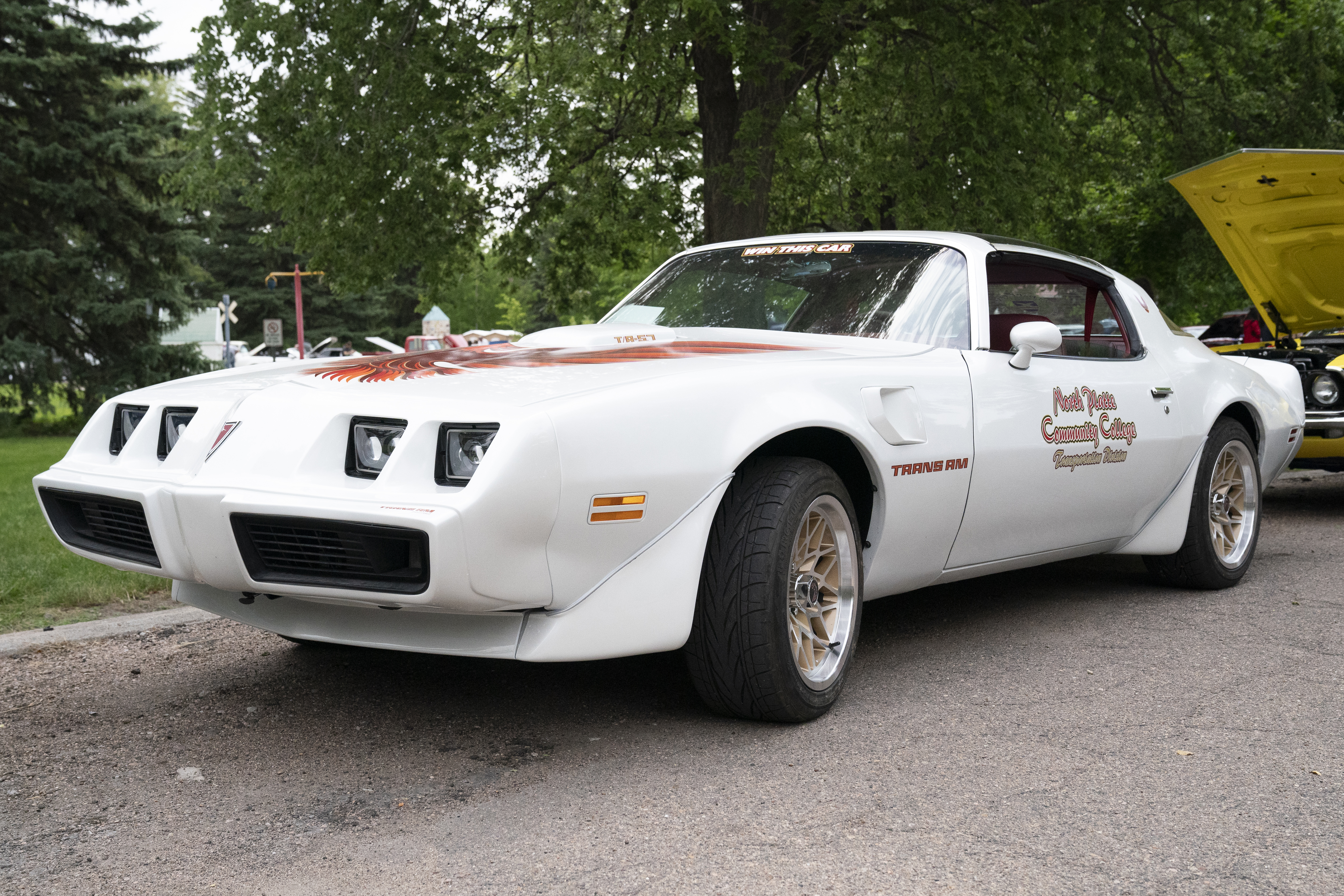 North Platte Community College unveils the 2024 raffle car, a 1979 Pontiac Trans Am, during the Buffalo Bill Kiwanis Antique Car Show & Parade at Memorial Park on Friday morning.
