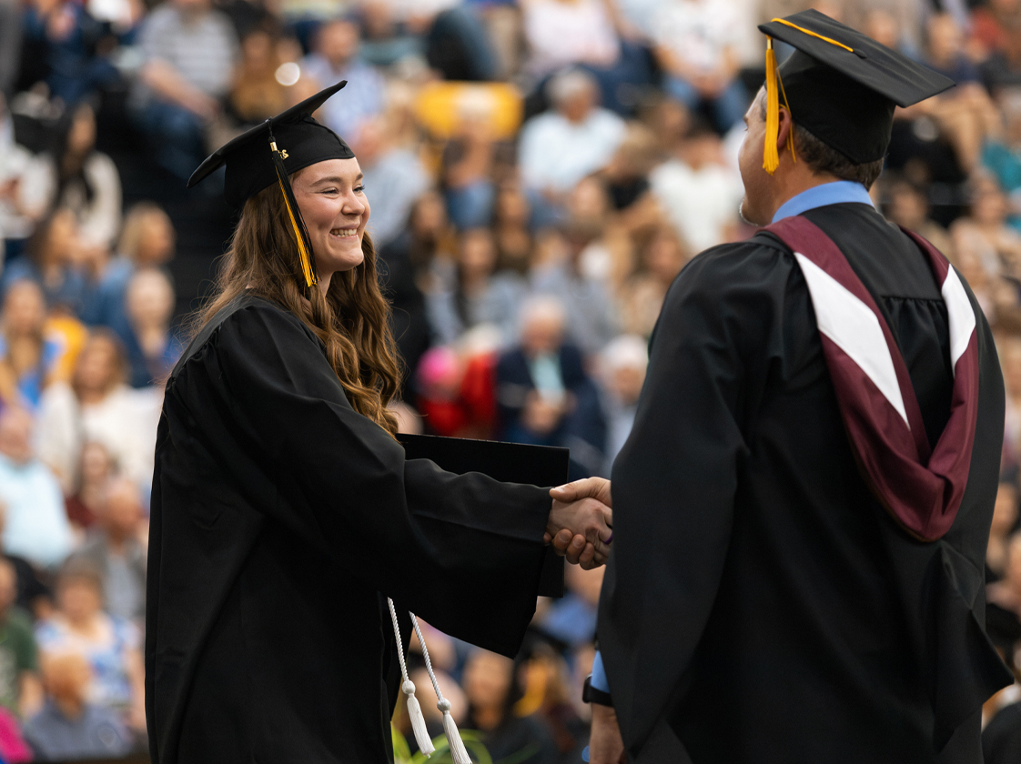 President Ryan Purdy shaking hands with student during 2024 commencement ceremony in North Platte.